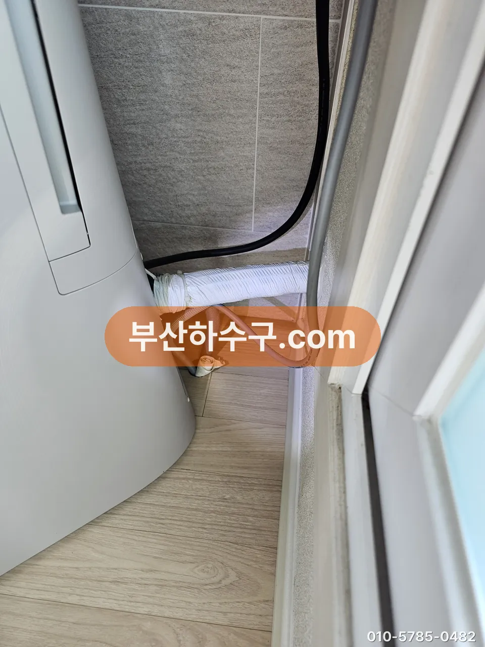 스탠드 에어컨 뒤 드레인 호스가 벽 쪽 배수관으로 이어지는 연결부, 물 떨어진 자리 확인