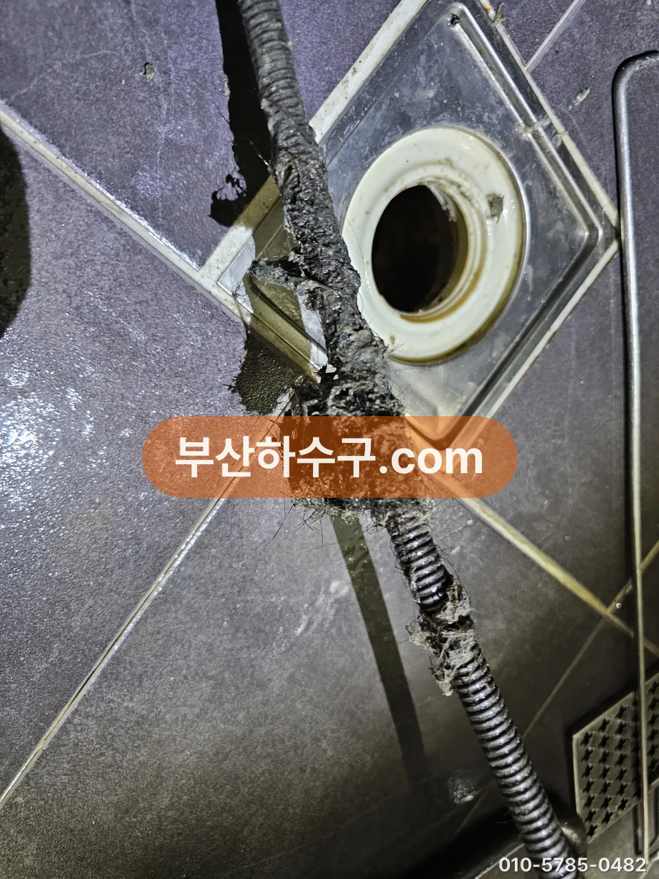 욕실 바닥 배수구에서 빼낸 스프링 장비에 걸려 나온 이물 뭉치, 물살로는 안 떨어지고 긁어내야 하는 층