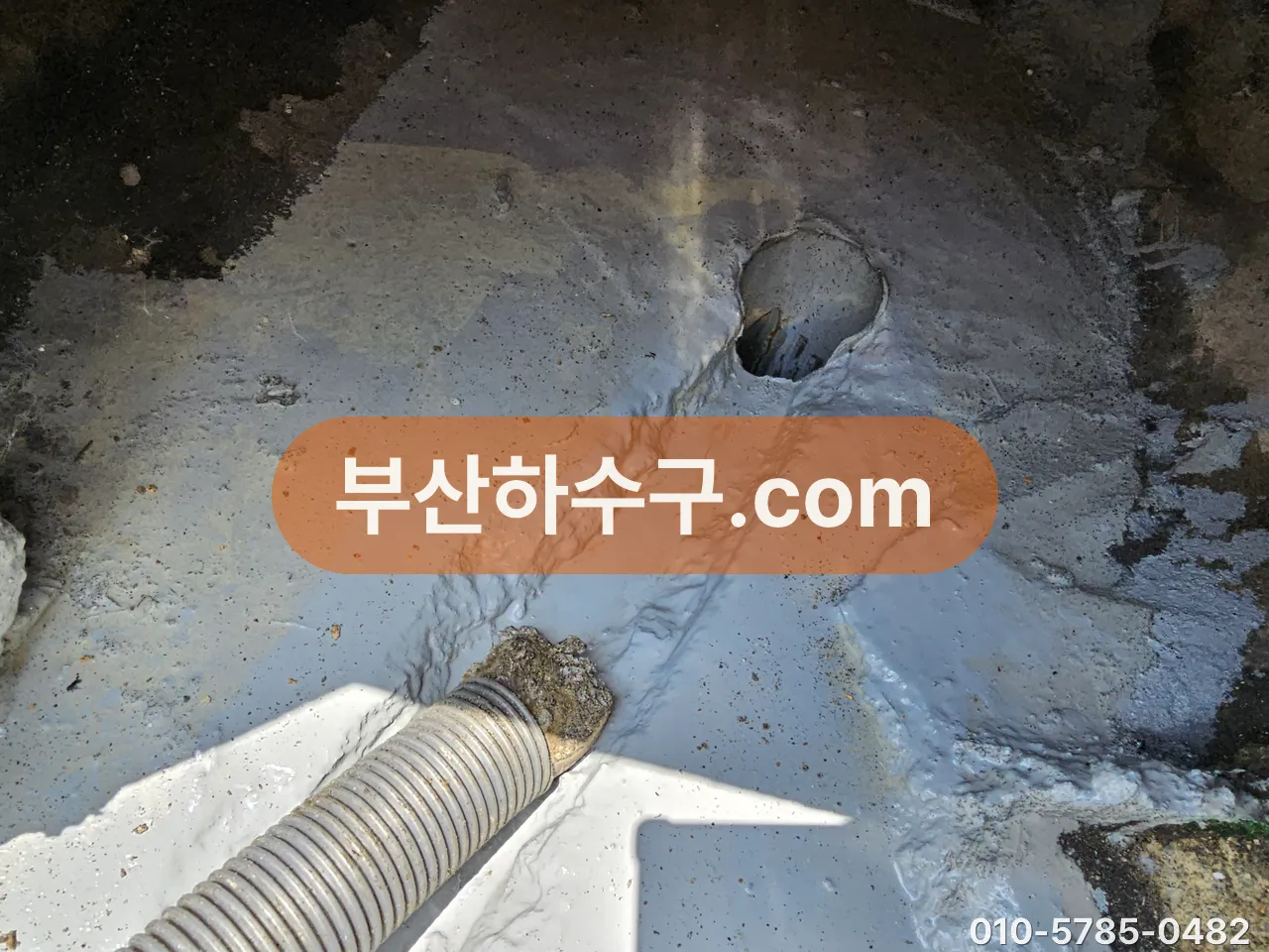 옥상 방수층 위 드레인 입구에 세척 호스를 넣은 상태, 배수구 둘레 방수면과 통수를 함께 보는 자리