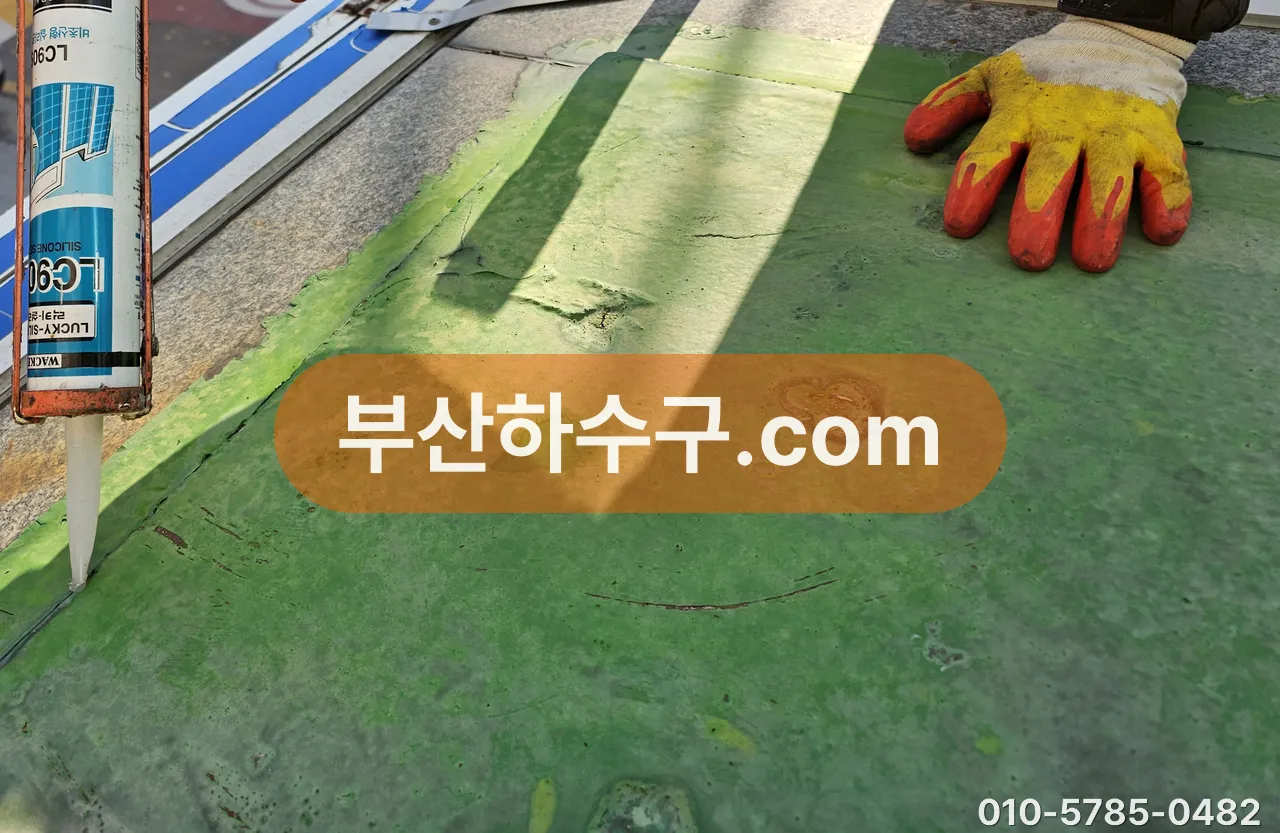 옥상 우레탄 방수면 위 이음 자리에 실리콘 코킹을 넣는 작업, 갈라진 부분 보수 장면