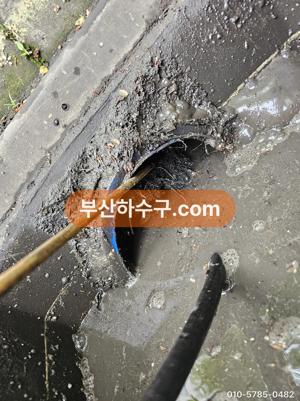 슬러지가 찬 배수관에 고압 노즐을 넣는 장면