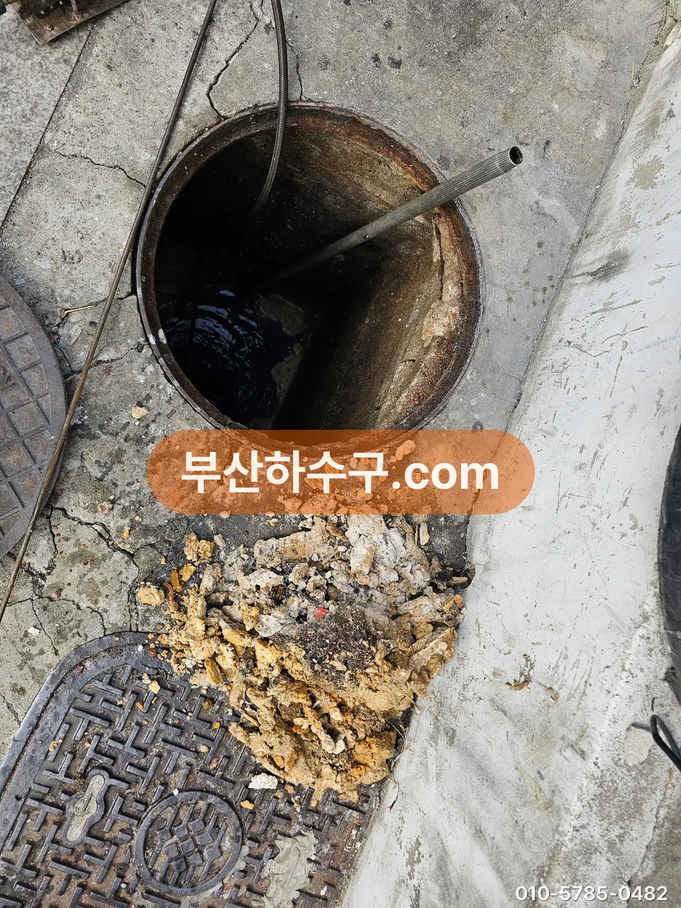 맨홀 안으로 고압 호스를 내려 관로를 세척하는 작업