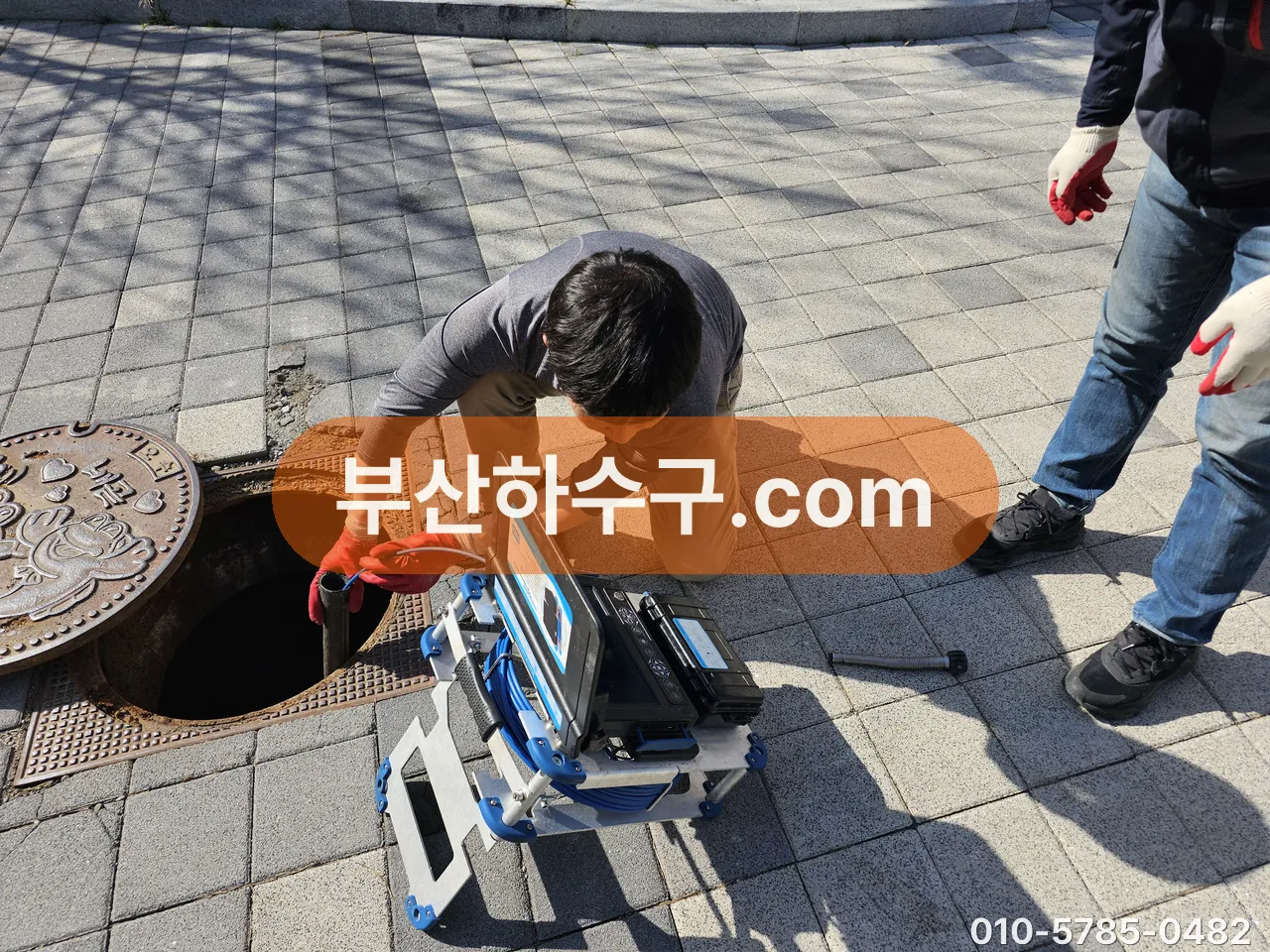 보도 맨홀에서 내시경 카메라를 투입하는 작업