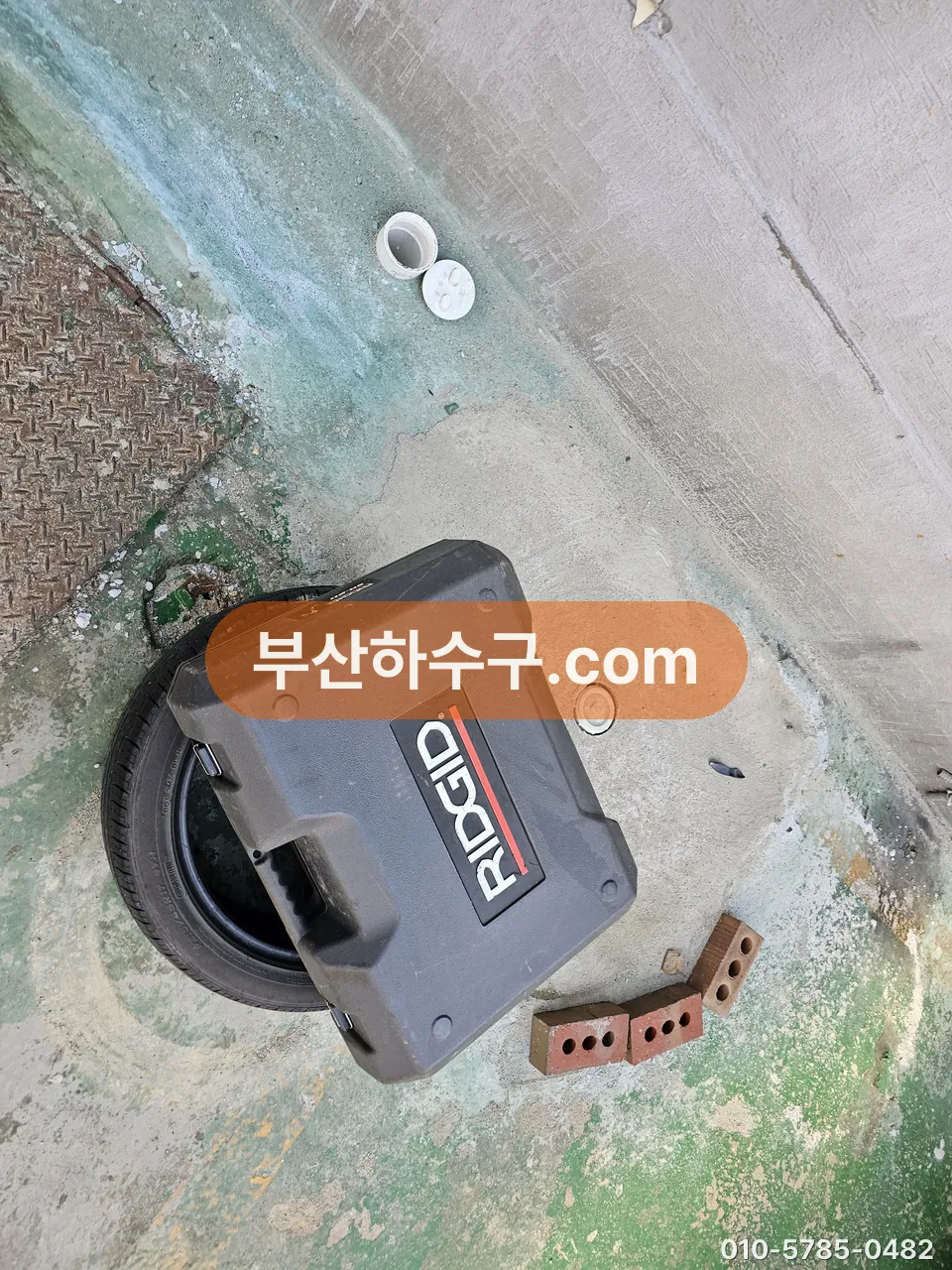 위치 탐지기로 바닥 아래 배관 경로를 확인하는 작업