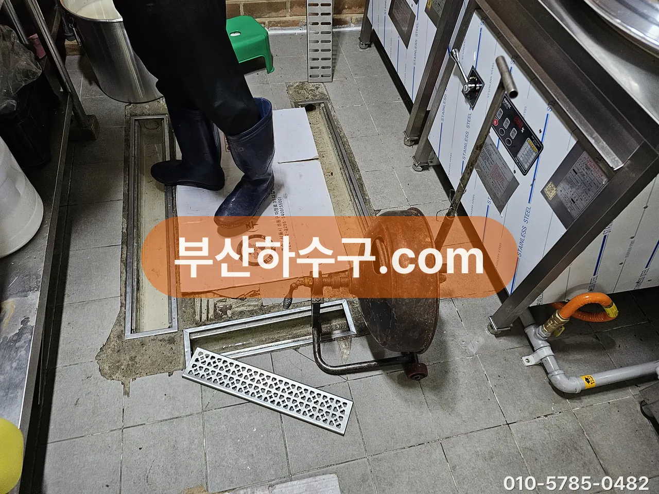식당 주방 바닥 트렌치 배수구에 스프링 장비를 넣어 라인을 훑는 장면