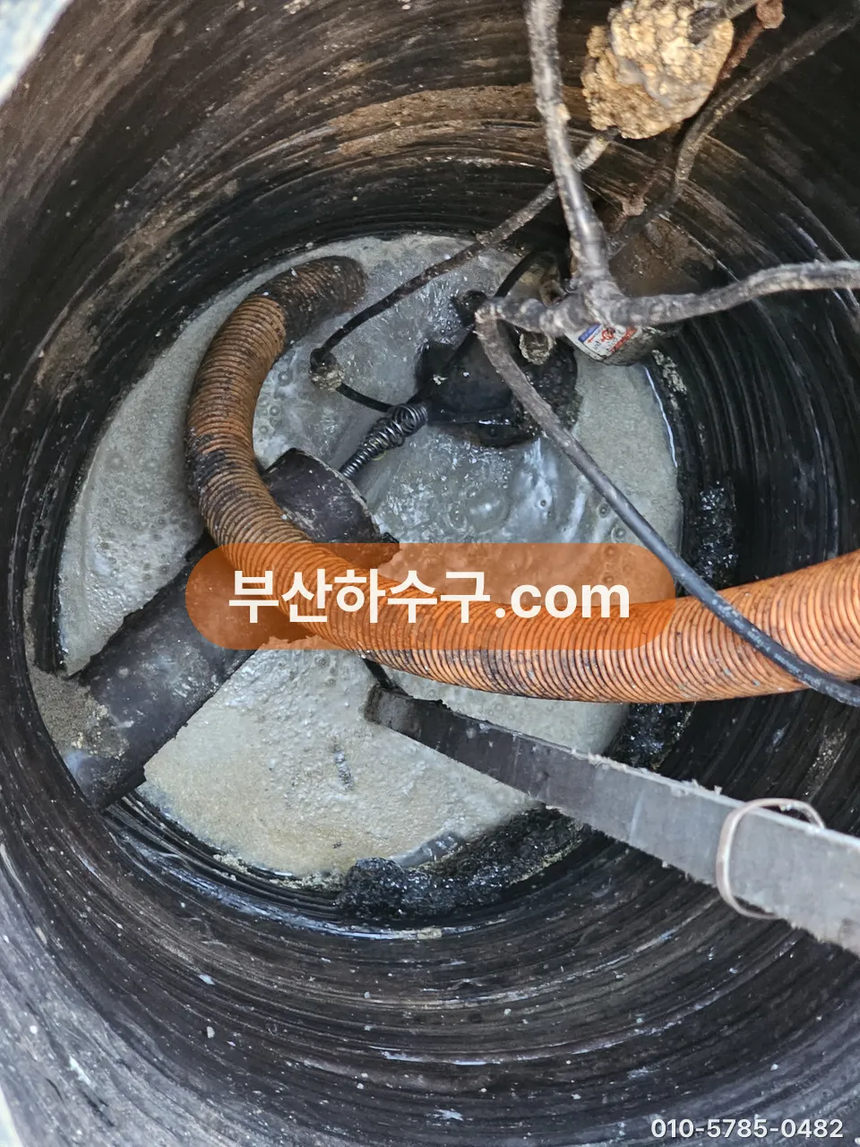 집수정 뚜껑을 열고 수중펌프 배출 호스와 바닥 슬러지 상태를 확인하는 장면