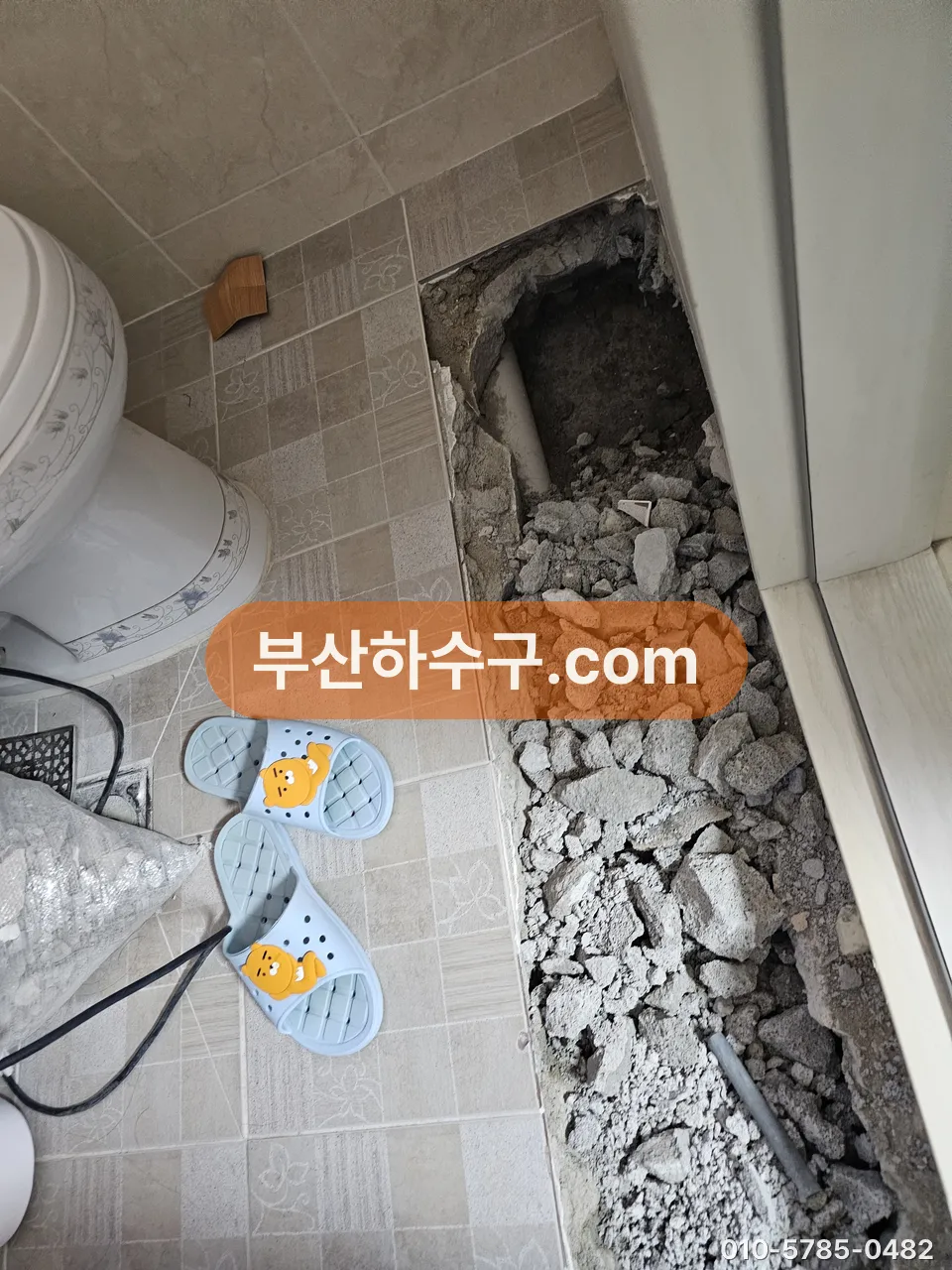 변기 옆 바닥을 헐어 플랜지 쪽 배관을 드러낸 모습, 흔들리던 변기의 바닥 상태 확인